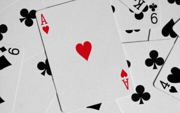 A close-up of playing cards with an Ace of Hearts on top
